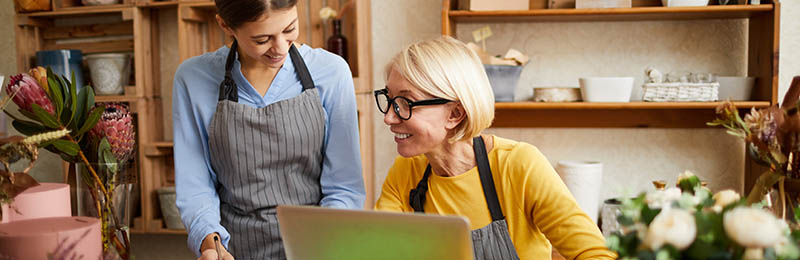 Female entrepreneur showing her business plan and pitch to a female relative, seeing if they want to help fund their business.