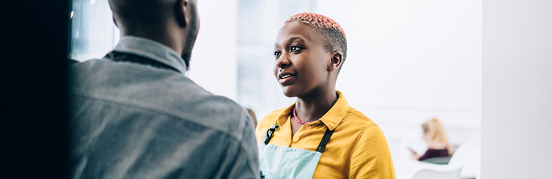 Female entrepreneur speaking with a colleague about the problem she is solving for customers with her business idea.