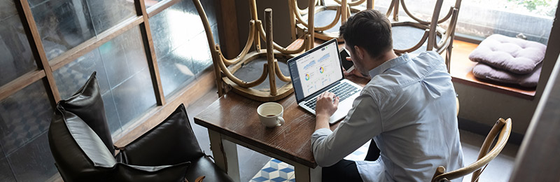 Male entrepreneur and restaurant owner sitting at a table while the location is closed. Working on a cash flow forecast to check on his business health.