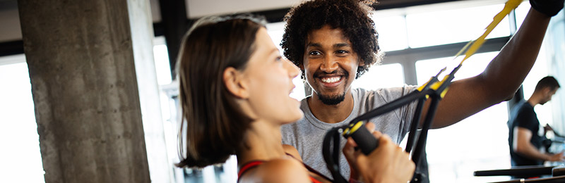 Gym owner assisting a client with exercising and reminded of what his mission is.