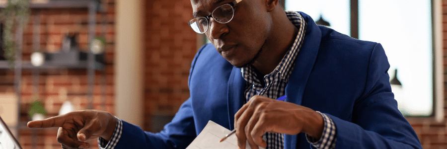 Male entrepreneur sitting at a desk working on writing an executive summary.